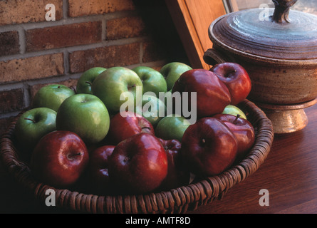 Äpfel in einem Korb auf einem Buffet in der Nähe eines Fensters mit natürlichem Licht Stockfoto
