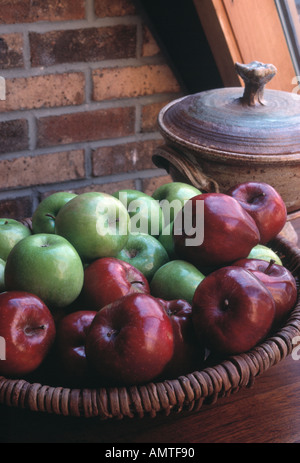 Äpfel in einem Korb auf einem Buffet in der Nähe eines Fensters mit natürlichem Licht Stockfoto