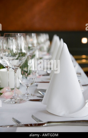 Gedeckter Tisch mit weißen gefalteten Servietten und Weingläser. Stockfoto