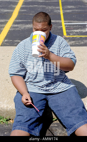 Übergewichtige Teenager männlich trinkt eine kalorienreiche Limonade Stockfoto