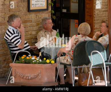 Zwei Paare genießen einen Drink in saßen draußen ein Straßencafé, Italien. Stockfoto