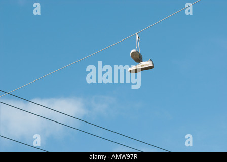 Ein paar weiße Turnschuhe von Freileitungen nach geworfen hängen dort als Teenager Streich Stockfoto