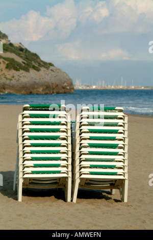 Grüne Sonnenliegen / Strandkörbe an einem Sandstrand in der kleinen Stadt von Garraf, Barcelona, Spanien, Südeuropa Stockfoto