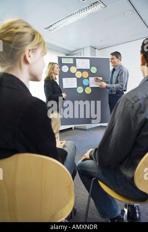 Seitenansicht von Mann und Frau sprechen vor Tafel Stockfoto