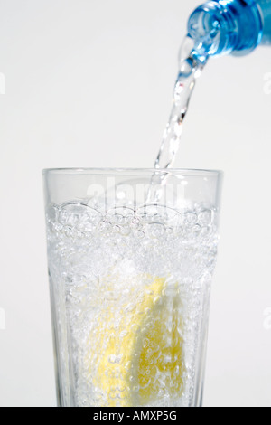 Nahaufnahme der Scheibe Zitrone und Wasser in Glas gegossen Stockfoto