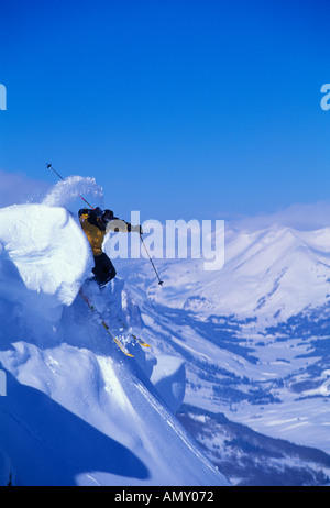 Ein Skifahrer springt durch ein Gesims Neuschnee auf dem Gipfel des Crested Butte Colorado Stockfoto