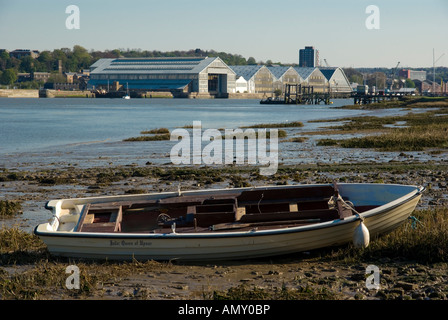 Boot am Strand mit Gebäuden im Hintergrund, Chatham, Südostengland, Medway, Kent, England Stockfoto