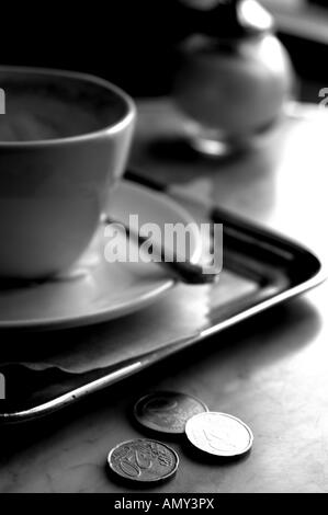 Nahaufnahme von Münzen und Kaffeetasse Stockfoto