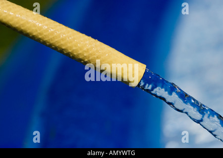 Gelben Gummirohr Schlauch füllt sich ein Planschbecken Stockfoto