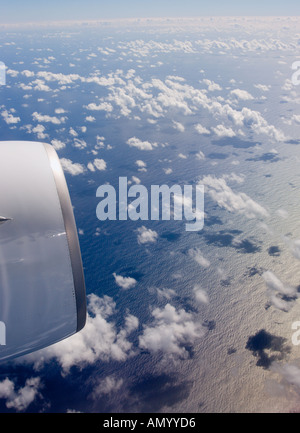 Luftbild vom Flugzeug mit Strahltriebwerk hoch über dem Pazifischen Ozean und optische Illusion von weißen Wolken fast bis zum Meer Stockfoto