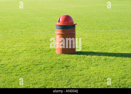 Rote Mülltonne auf einem Sportplatz Stockfoto