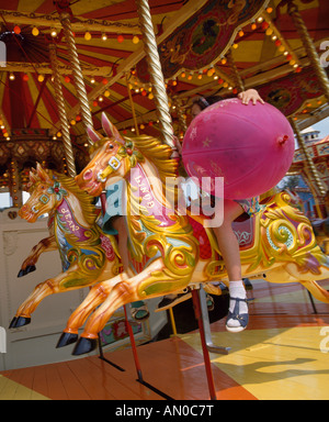 junges Mädchen mit Ballon auf Kirmes Fahrt, Norfolk, england Stockfoto