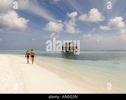 Nord Male Atoll Meeru Island Resort auf den Malediven paar zu Fuß am Strand vorbei Honeymoon Villa am Wasser Stockfoto