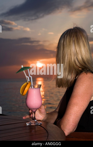 Malediven Süd Male Atoll Olhuveli Resort einen mittleren Alters Frauen sunset Cocktail genießen Stockfoto