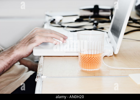 Mann sitzt am Laptop Stockfoto