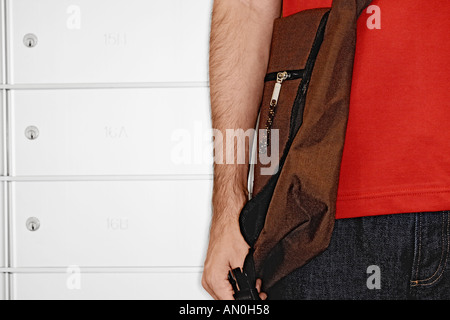 Mann mit Messanger Bag stand vor Briefkästen Stockfoto