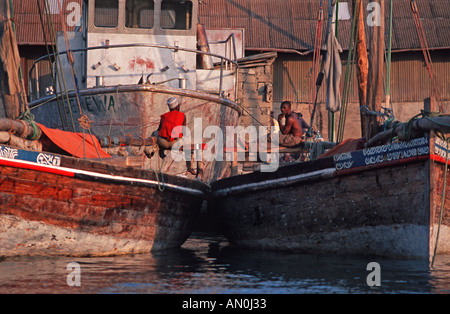 Fischer sitzt auf ihr Boot in den späten Nachmittag Stone Town Hafen Unguja Sansibar Tansania Stockfoto