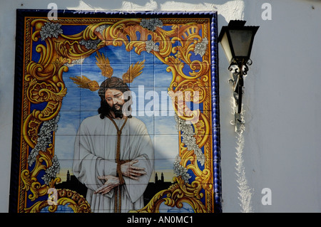 Ein Azulejo Keramik Handarbeit Darstellung Jesu Christi ziert eine Gebäudehülle in der Compas de San Francisco, Córdoba, Spanien. Stockfoto