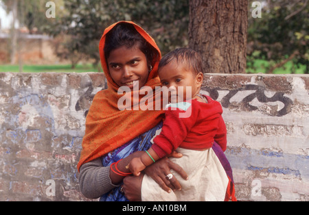 Junge Frau im Straße halten Baby Lächeln auf den Lippen. Indien Stockfoto