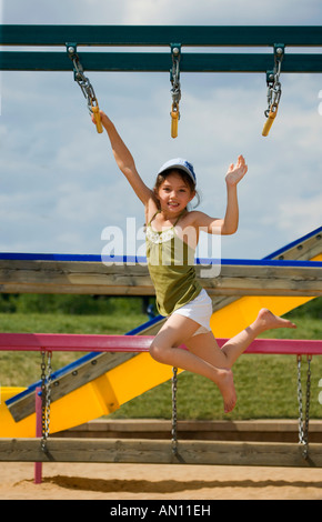 Mädchen schwingen auf Klettergerüst Stockfoto