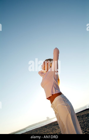 entspannende junge Frau am Strand Stockfoto