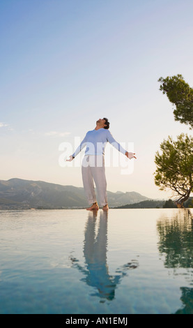 Der Mensch steht im offenen Raum Himmel und reflektierenden Pool Arme. Stockfoto