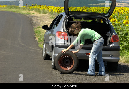 Frau ändern ihre Reifenpanne Stockfoto