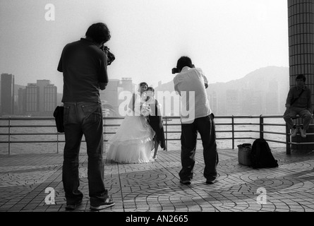 Junge Braut hat Foto mit Familienmitglied an der Uferpromenade in Tsim Sha Tsui Kowloon Hong Kong Stockfoto