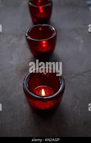 eine Reihe von roten Glas-Kerzenhalter mit Glitzer Kerzen Stockfoto