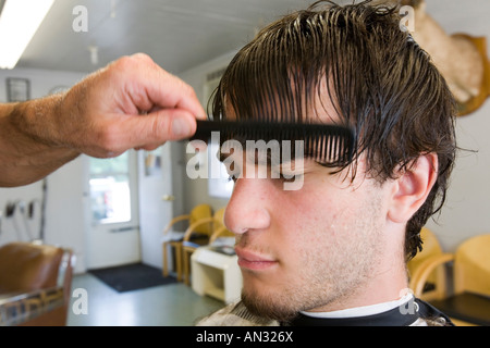 Ein männlicher Jugendlicher erhält einen Haarschnitt in einem Friseur. Stockfoto