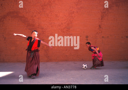 Tibetische Mönche nehmen sich Zeit vom Gebet, um Fußball zu spielen. Stockfoto