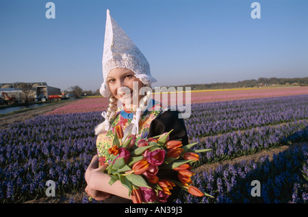 Blumenfelder / Tulpenfelder / Mädchen gekleidet in niederländischen Kostüm mit Tulpen, Lisse, Holland (Niederlande) Stockfoto