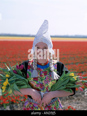 Blumenfelder / Tulpenfelder / Mädchen gekleidet in niederländischen Kostüm mit Tulpen, Lisse, Holland (Niederlande) Stockfoto