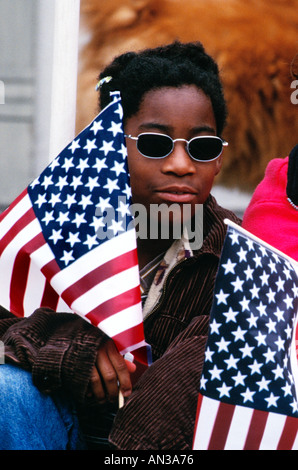 Afrian amerikanische weibliche Teen mit amerikanischen Flaggen beobachten 4. Juli Parade Stockfoto