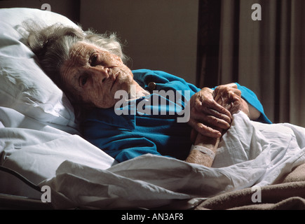 Kaukasische Seniorin im Bett liegend in Pflegeheim Stockfoto