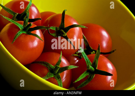 Rote Cherry-Tomaten in eine grüne gelbe Schale Stockfoto