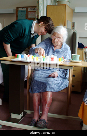 Ältere Frau spielt Solitaire mit einer Krankenschwester im Krankenhaus Ward England UK Stockfoto