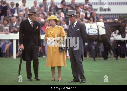 Lord Porchester The Earl Carnarvon (links) Queen Elizabeth II in gelbem Kleid mit Höfling beim Derby Day Pferderennen Epsom Downs Surrey 1984 1980s UK Stockfoto