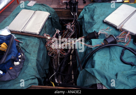 Geschützte offene British Telecom Kabel Schacht im Pflaster mit freiliegenden Kabel zu sehen Stockfoto