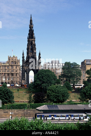 Bahnreisende der Stadt Edinburgh am Bahnhof Waverley mit historischem Denkmal für Sir Walter Scott Beyond mit Geschäft und Hotel in Schottland, Großbritannien Stockfoto
