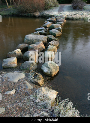 Steine über einen gefrorenen Gartenteich zu treten, Finnland Stockfoto