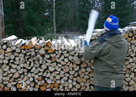 Ältere Menschen häufen Bestand von Brennholz, Finnland Stockfoto