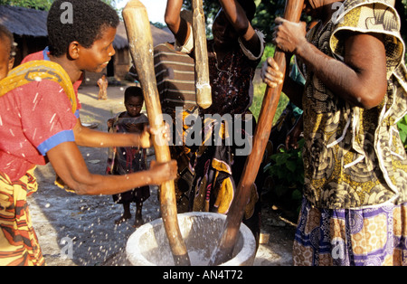 Dorfbewohner Stampfen von Reis in grossen Mörser, Afrika Stockfoto
