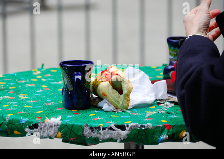 Besucher Gluewein (warme deutsche Kraut Wein) trinken und Essen Bratwurst auf dem Christkindle-Markt in Chicago Illinois USA Stockfoto