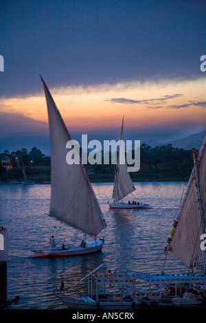 Luxor bei Sonnenuntergang mit Feluken Segeln auf dem Nil Stockfoto