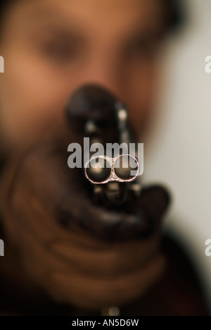 Unerkennbar Person mit dem Ziel, die Kamera mit einer doppelläufigen Pistole Stockfoto