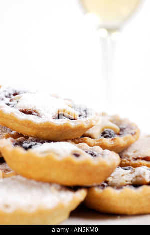 Mince Pies gestapelt auf Platte mit Glas Sherry im Hintergrund Stockfoto