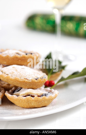 Teller mit Hackfleisch Kuchen verziert mit Holly Zweig und Christmas Cracker und Glas Sherry im Hintergrund Stockfoto