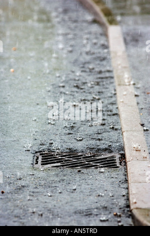 Regenwasser läuft in einen Abfluss während eines Sturms. Stockfoto