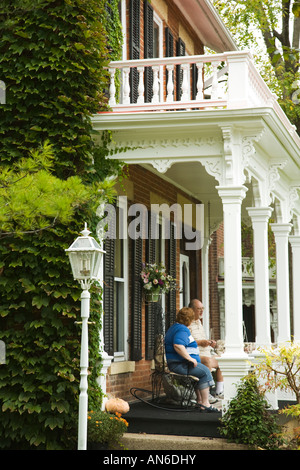ILLINOIS Galena paar sitzen auf der Veranda des Bed &amp; Breakfast Efeu wächst auf Gebäude Stockfoto